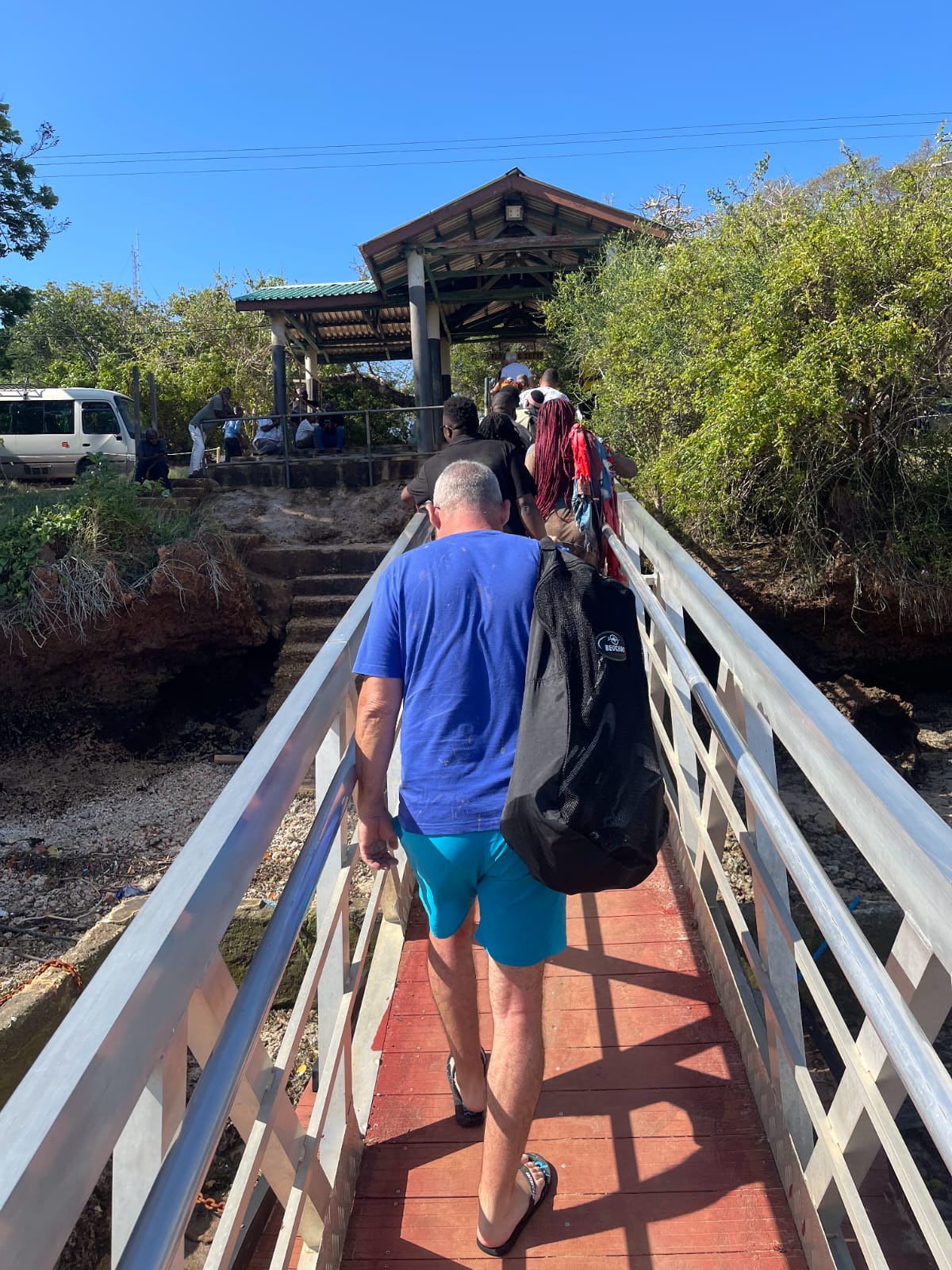 Guest crossing a wooden jetty on the way to the boat