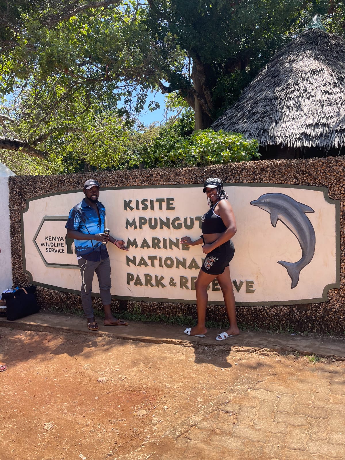Guests posing at the Kisite-Mpunguti Marine National Park entrance sign