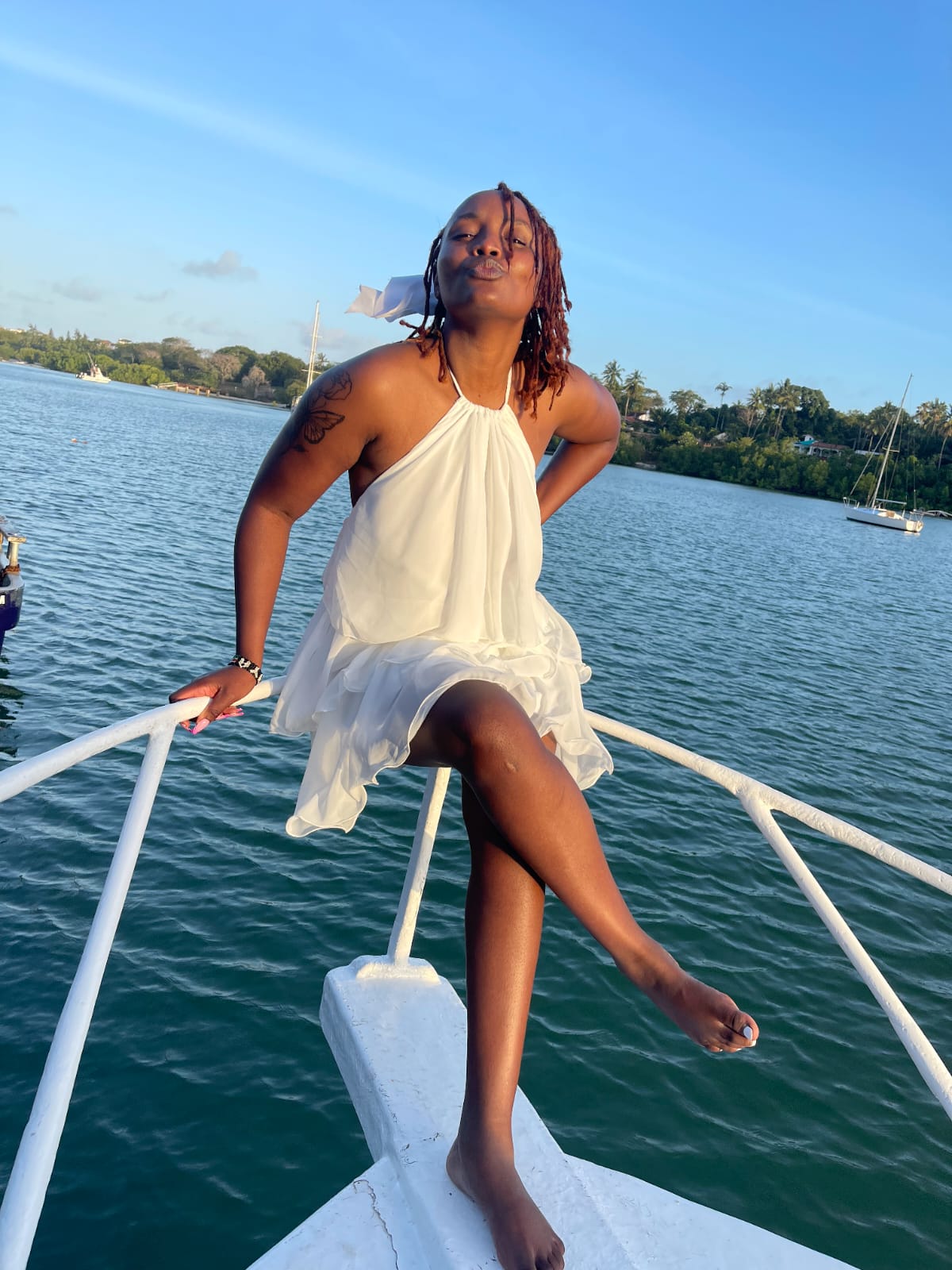 Guest smiling on the bow of the boat as the sun sets over the creek