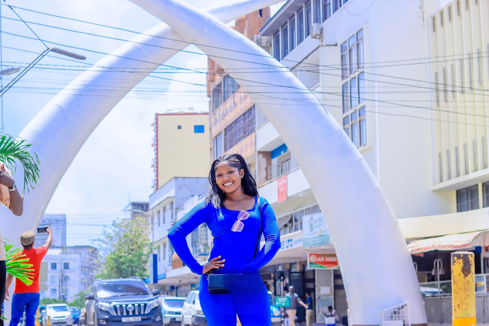 Guest in blue posing beneath the Mombasa Tusks