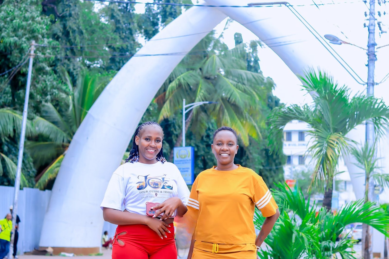 Two guests smiling under the Mombasa Tusks