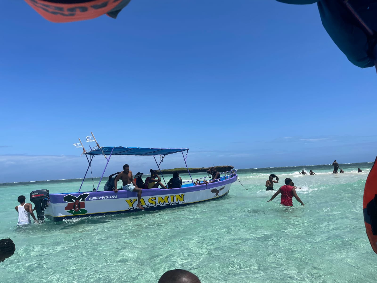 Guests swimming beside the Yasmin boat in shallow reef water
