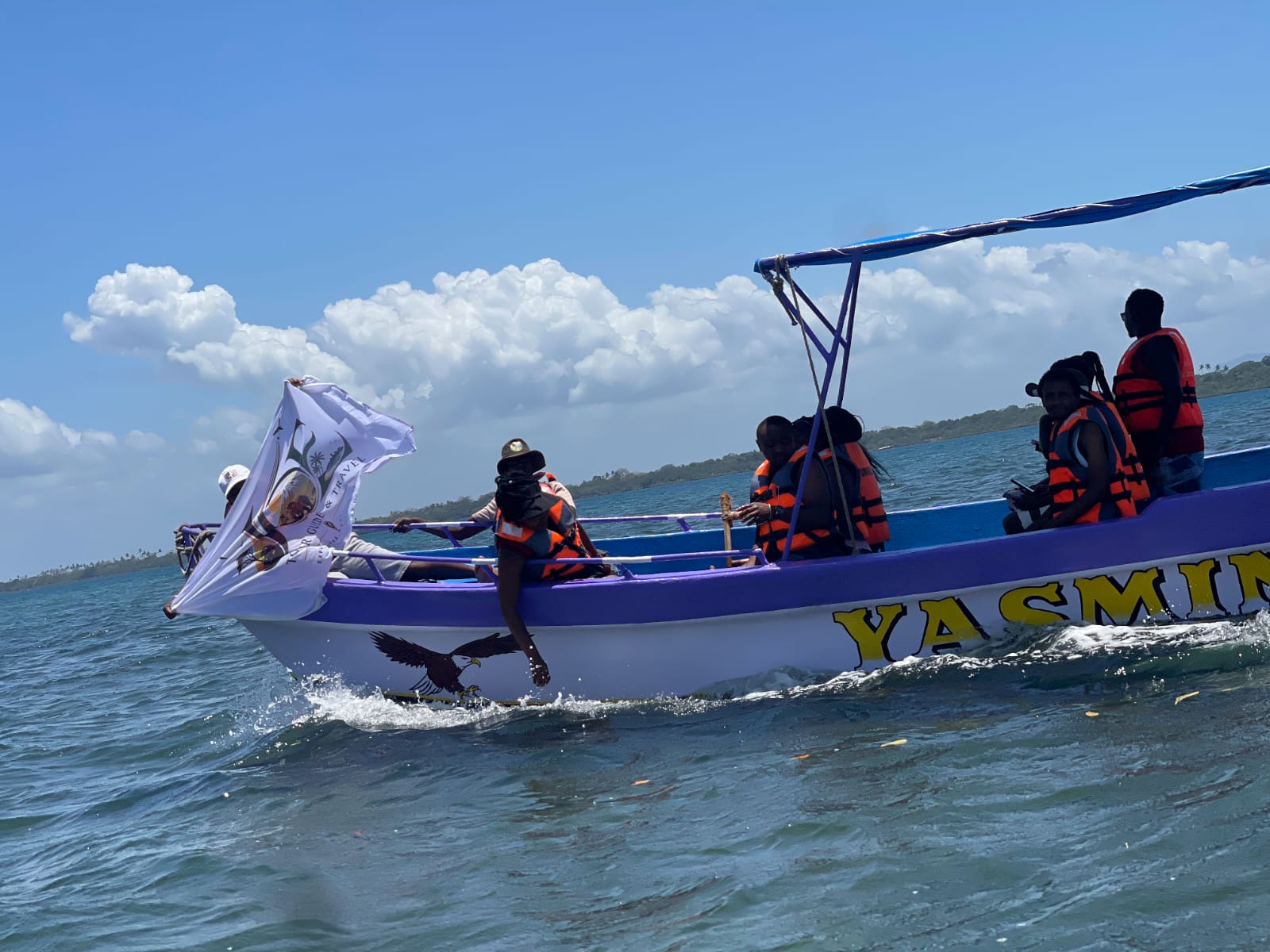 The Yasmin boat speeding across the water with the JOE flag flying